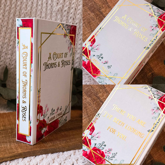 Book titled 'A Court of Thorns & Roses' with decorative cover on a wooden surface.