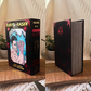 A boxed book or volume titled "Jujutsu Kaisen" shown in two views on a wooden surface. The left view shows the front cover with illustrated artwork and text including "Volumes 4-6" and "Gege Akutami.