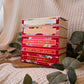 Stack of books titled 'A Court of Thorns & Roses' series on a wooden surface with a soft, textured background.