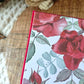 Red book with floral design end pages on a textured surface